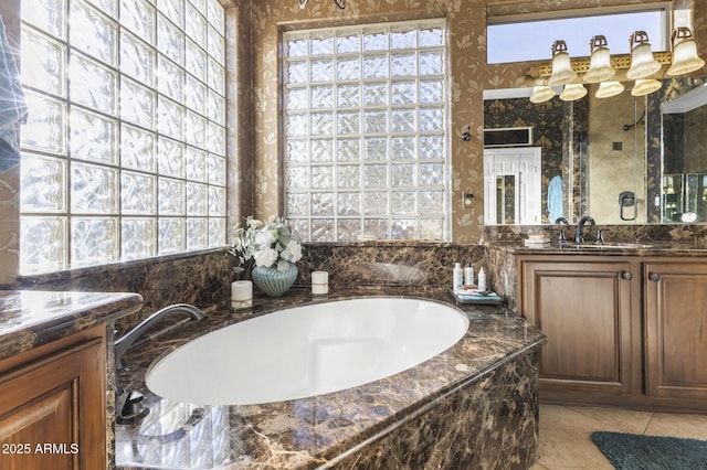 bathroom with vanity, tile patterned flooring, and a relaxing tiled tub