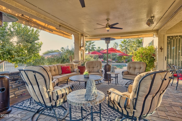 view of patio featuring ceiling fan, a fenced in pool, and an outdoor hangout area