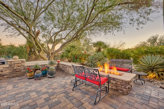 patio terrace at dusk featuring an outdoor fire pit