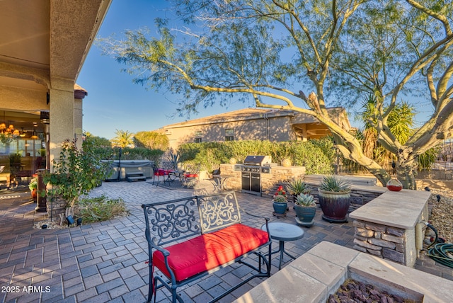 view of patio / terrace featuring area for grilling, an outdoor kitchen, and a hot tub