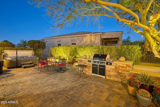 view of patio / terrace with a hot tub, area for grilling, and grilling area