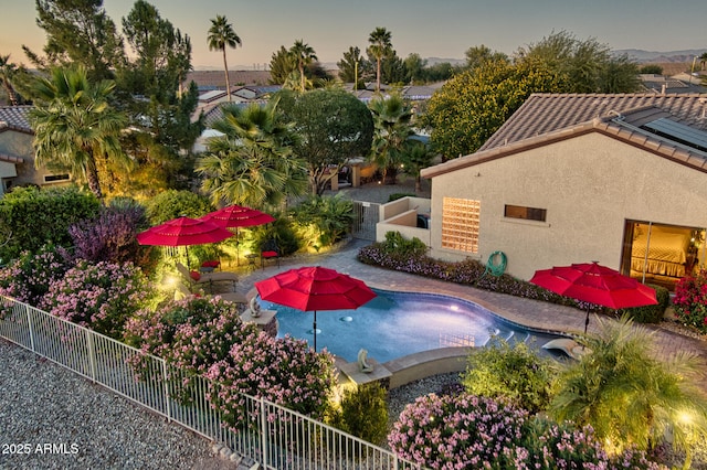 pool at dusk featuring a patio