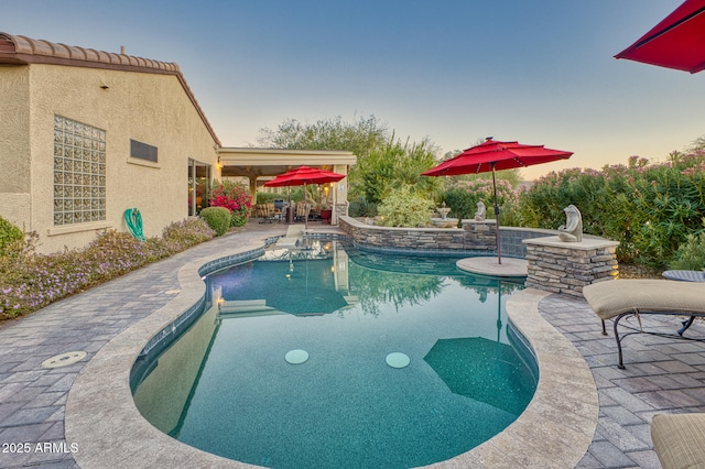 pool at dusk with a patio