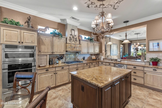 kitchen with sink, a center island, stainless steel appliances, tasteful backsplash, and a notable chandelier