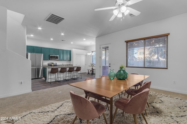 carpeted dining room with ceiling fan