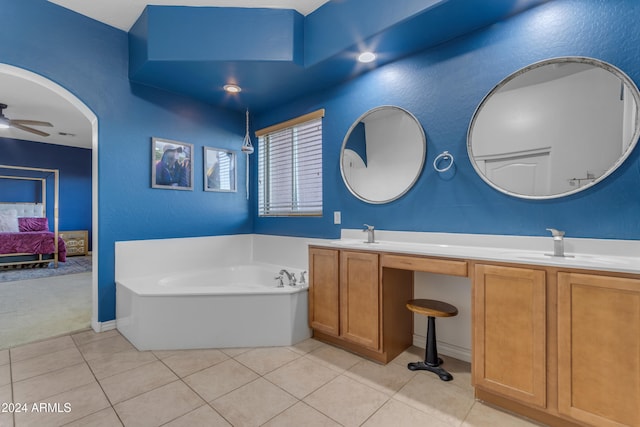 bathroom featuring tile patterned flooring, vanity, a tub, and ceiling fan