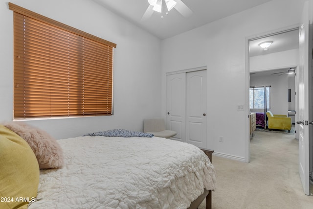 carpeted bedroom featuring ceiling fan and a closet