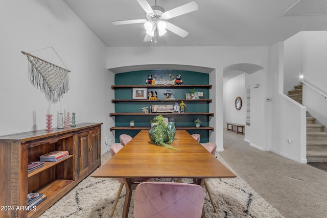 carpeted dining area with ceiling fan