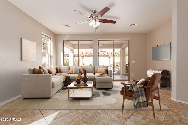 living area with a wealth of natural light, visible vents, and ceiling fan