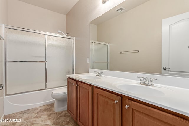 full bathroom with vanity, shower / bath combination with glass door, and toilet