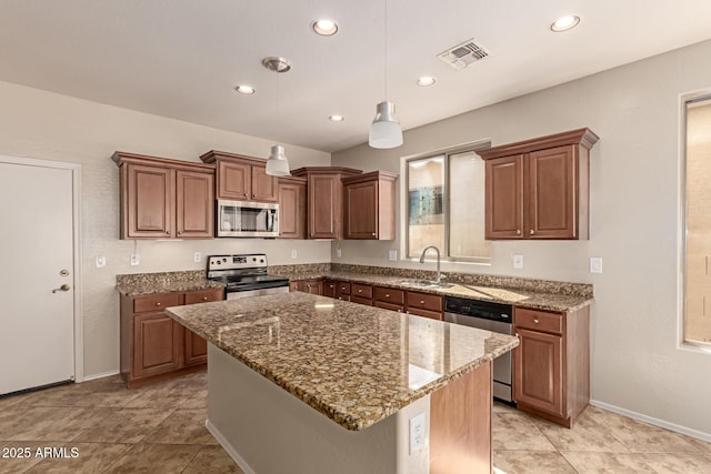 kitchen with sink, decorative light fixtures, a center island, appliances with stainless steel finishes, and light stone countertops