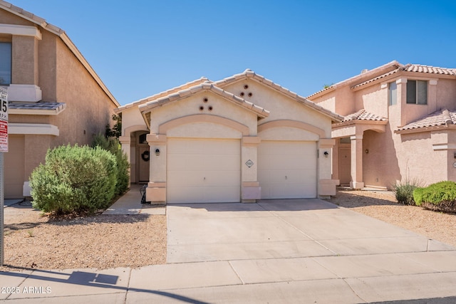mediterranean / spanish house featuring an attached garage, stucco siding, driveway, and a tiled roof