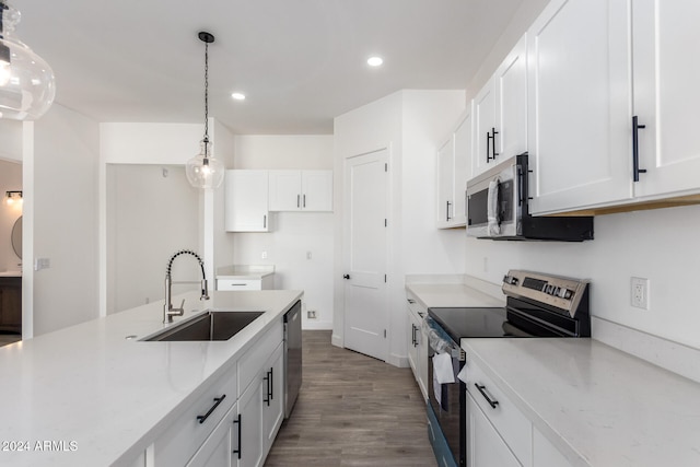 kitchen featuring appliances with stainless steel finishes, decorative light fixtures, white cabinetry, and sink