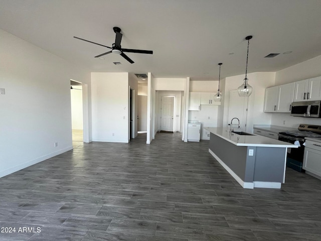 kitchen with pendant lighting, a center island with sink, white cabinets, sink, and appliances with stainless steel finishes