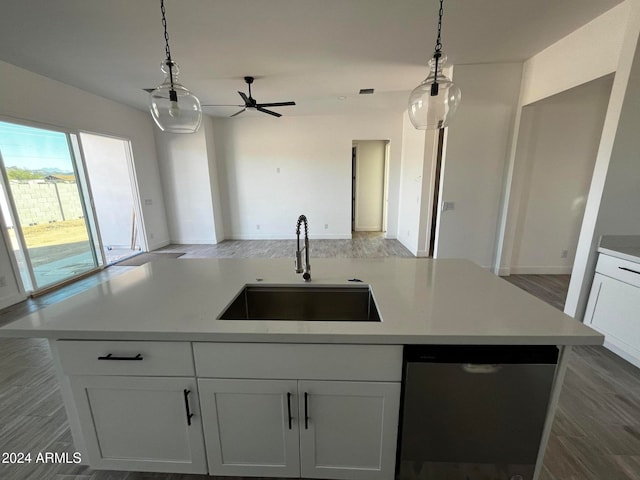 kitchen featuring pendant lighting, white cabinetry, and sink