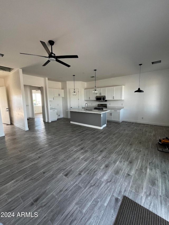 kitchen featuring white cabinets, pendant lighting, dark hardwood / wood-style flooring, and an island with sink