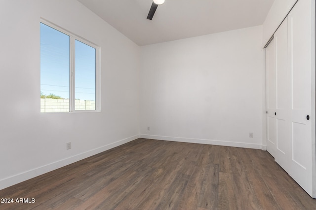 unfurnished bedroom featuring ceiling fan, dark wood-type flooring, and a closet