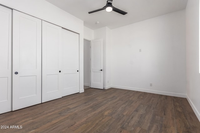 unfurnished bedroom with ceiling fan, a closet, and dark wood-type flooring