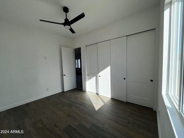 unfurnished bedroom with dark hardwood / wood-style flooring, a closet, and ceiling fan