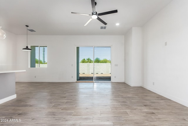 unfurnished room with light wood-type flooring and ceiling fan