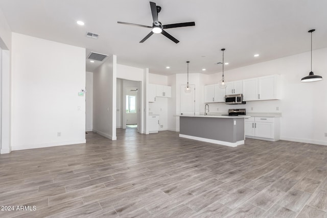 unfurnished living room featuring light hardwood / wood-style flooring and ceiling fan