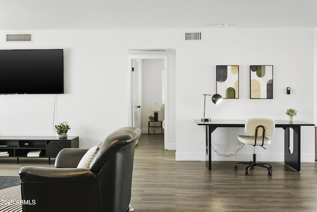 living area with baseboards, wood finished floors, and visible vents