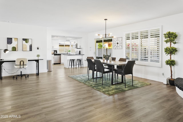 dining space with light wood finished floors, baseboards, and a notable chandelier