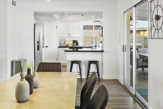 dining room featuring baseboards, wood finished floors, and visible vents