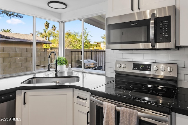 kitchen with stainless steel appliances, a sink, backsplash, and a wealth of natural light