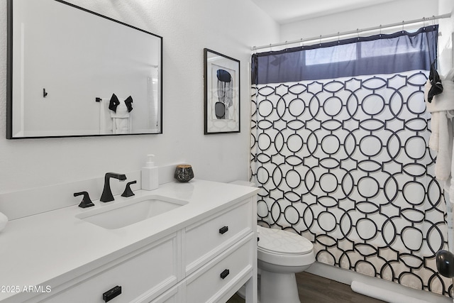bathroom with shower / tub combo with curtain, wood finished floors, vanity, and toilet