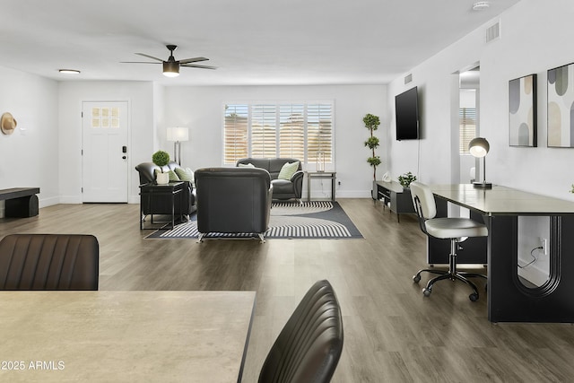 living room featuring a ceiling fan, wood finished floors, visible vents, and plenty of natural light