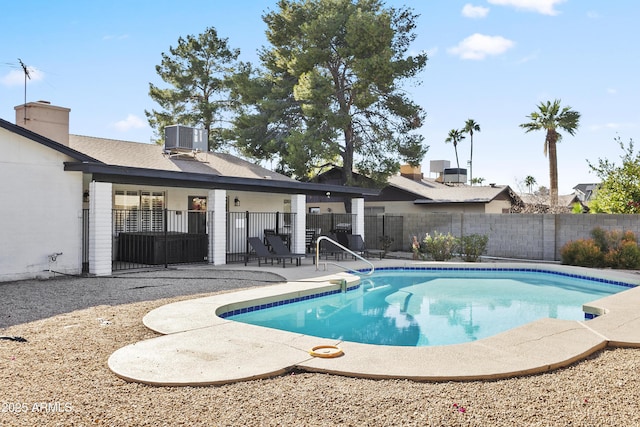 view of pool with a fenced backyard, a fenced in pool, central AC, and a patio