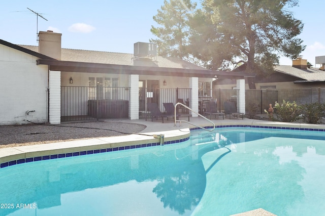 view of pool with fence, a patio, cooling unit, and a fenced in pool