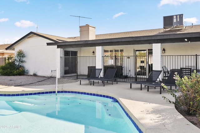 back of house featuring fence, a patio area, a fenced in pool, and cooling unit