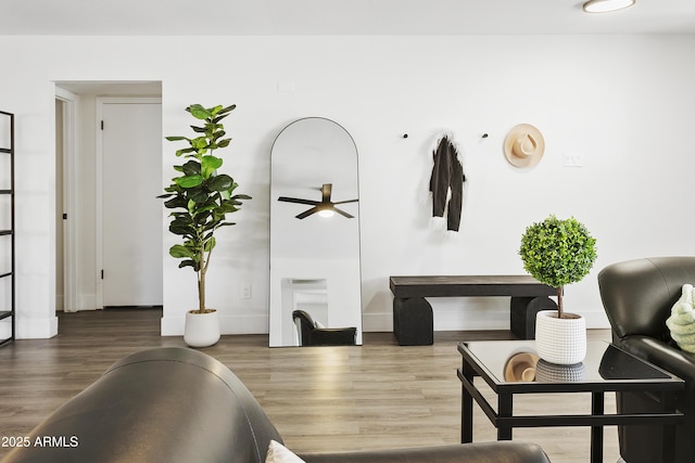 living area featuring baseboards, wood finished floors, and ceiling fan