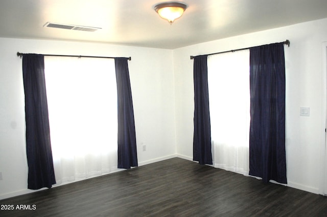 unfurnished room featuring dark wood-style floors and baseboards