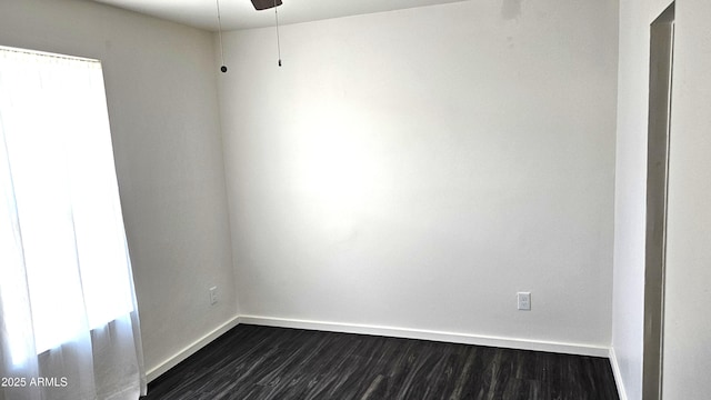 spare room with dark wood-style floors and baseboards
