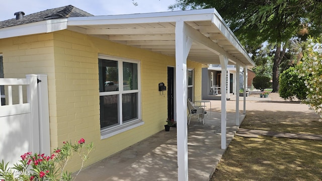 view of home's exterior with concrete block siding and a patio area