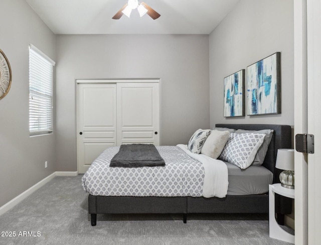 carpeted bedroom featuring baseboards, a ceiling fan, and a closet