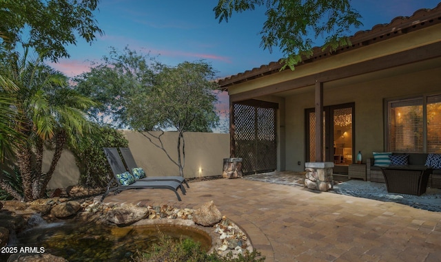 patio terrace at dusk featuring a patio and an outdoor hangout area