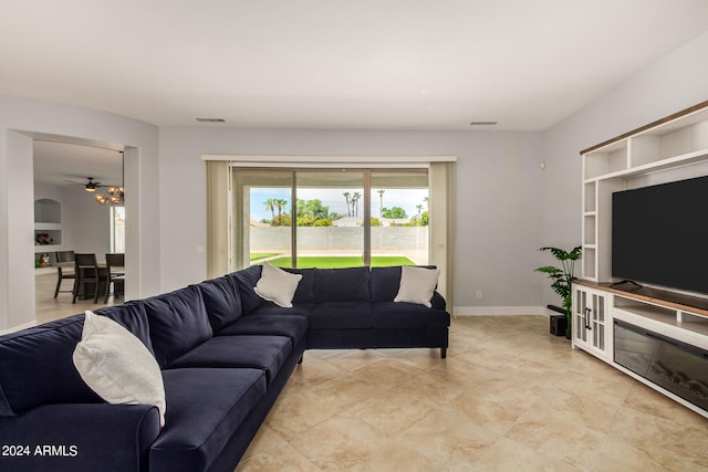 living room featuring built in features, light tile patterned floors, and ceiling fan