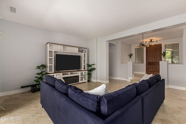 tiled living room featuring an inviting chandelier