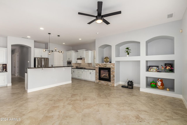 kitchen featuring white cabinets, built in features, ceiling fan, decorative light fixtures, and stainless steel fridge