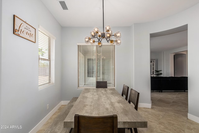 dining room with light tile patterned flooring and a notable chandelier