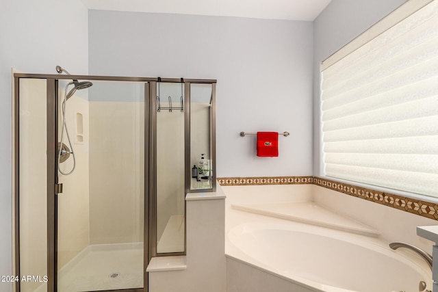 bathroom featuring independent shower and bath