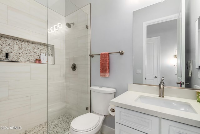 bathroom with a shower with door, toilet, and vanity