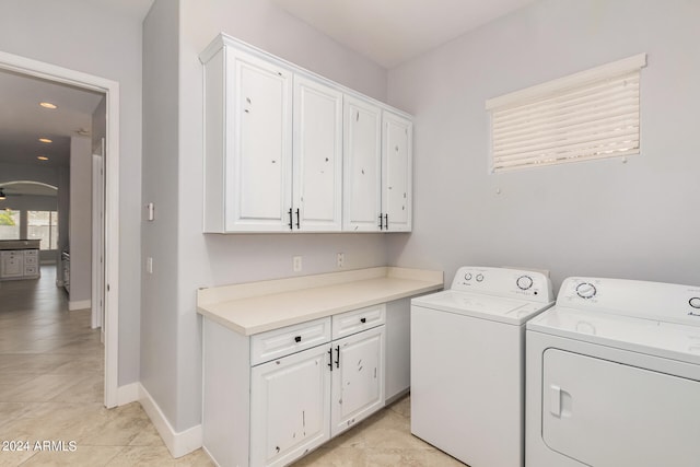 laundry room with cabinets, light tile patterned floors, and independent washer and dryer