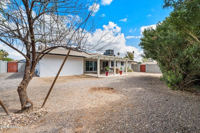 view of front of property with a patio area, stucco siding, a pergola, and a gate