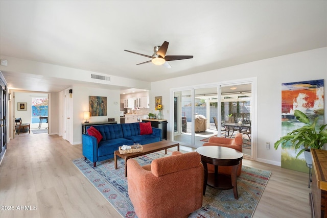 living area with visible vents, plenty of natural light, ceiling fan, and light wood-style flooring