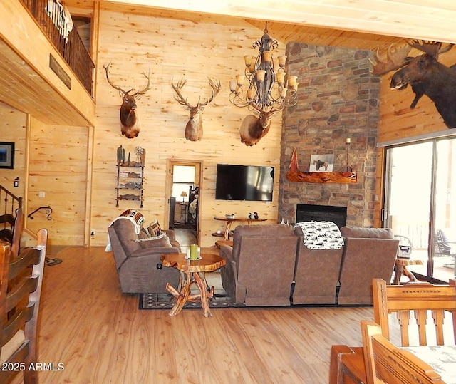 2372 Summer Loop, Forest Lakes, AZ 85931 - living room with wooden walls, high vaulted ceiling, wood finished floors, a stone fireplace, and a chandelier